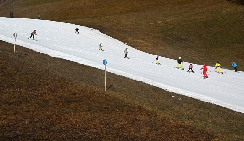 Skiers gliding down an artificial snow slope