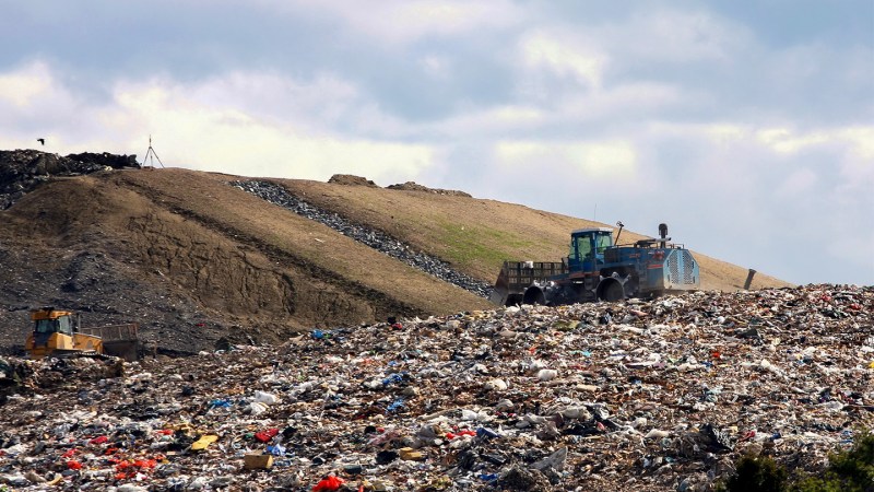 A bulldozer is shown in a landfill.